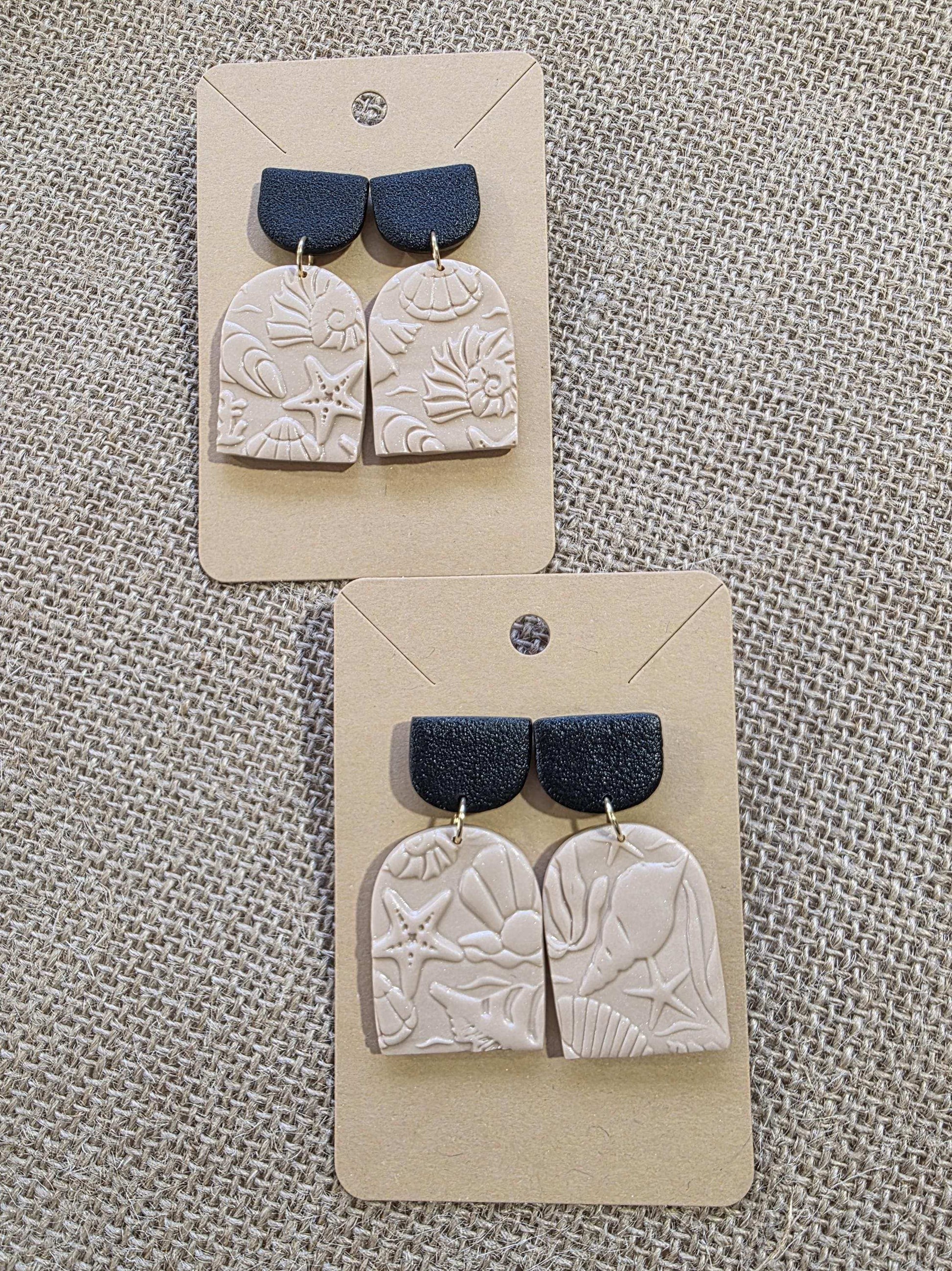 Boucle d'oreille "Empreintes salées" (argile polymère couleur sable et noire aux motifs marins) Collection "Sous l'Océan" été 2025