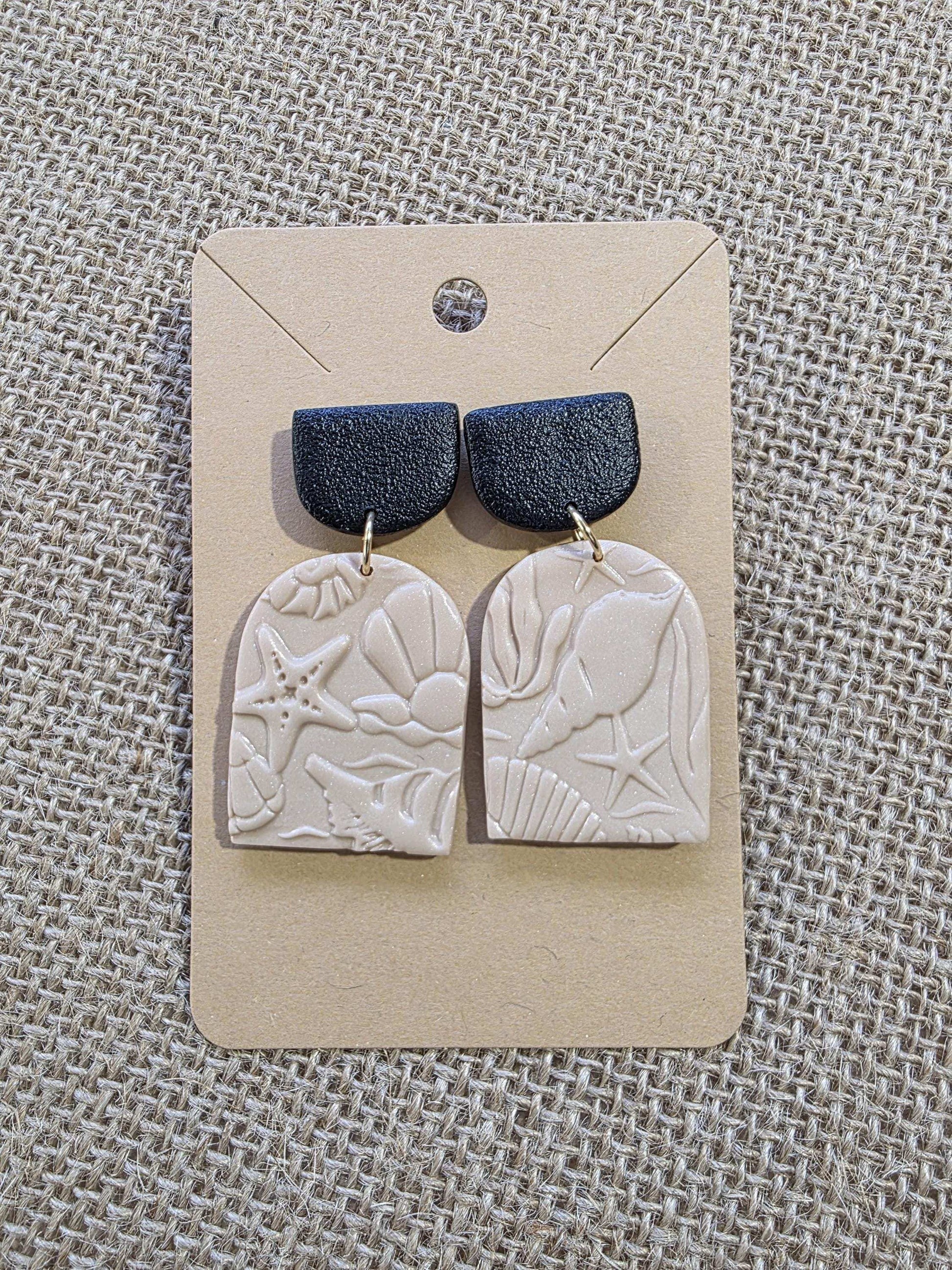 Boucle d'oreille "Empreintes salées" (argile polymère couleur sable et noire aux motifs marins) Collection "Sous l'Océan" été 2025