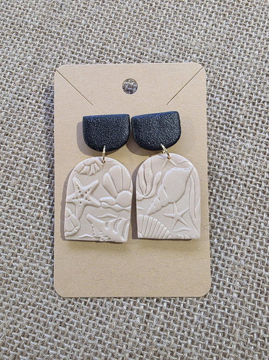 Boucle d'oreille "Empreintes salées" (argile polymère couleur sable et noire aux motifs marins) Collection "Sous l'Océan" été 2025