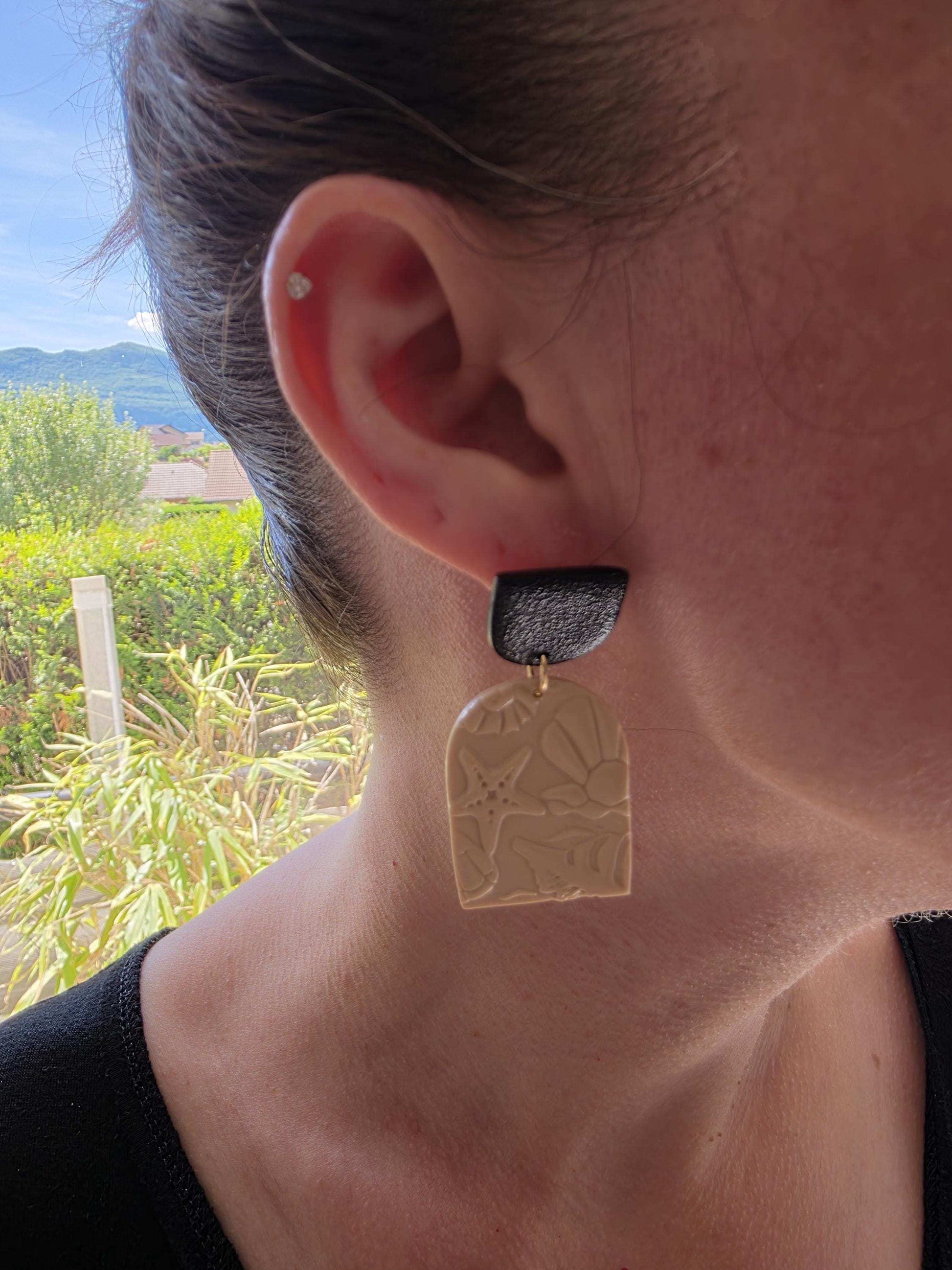 Boucle d'oreille "Empreintes salées" (argile polymère couleur sable et noire aux motifs marins) Collection "Sous l'Océan" été 2025