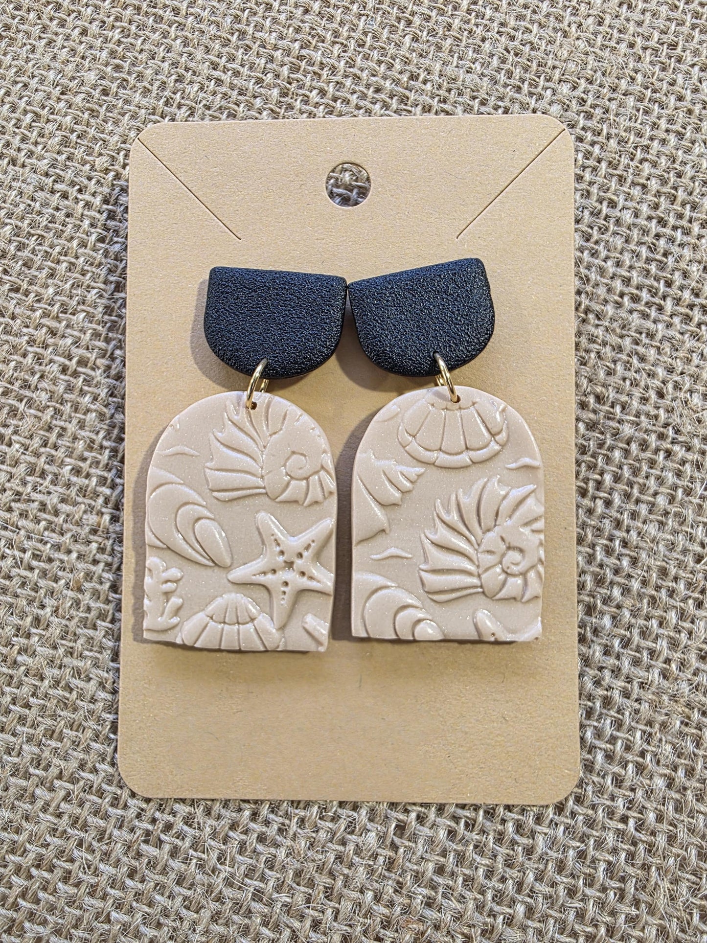 Boucle d'oreille "Empreintes salées" (argile polymère couleur sable et noire aux motifs marins) Collection "Sous l'Océan" été 2025